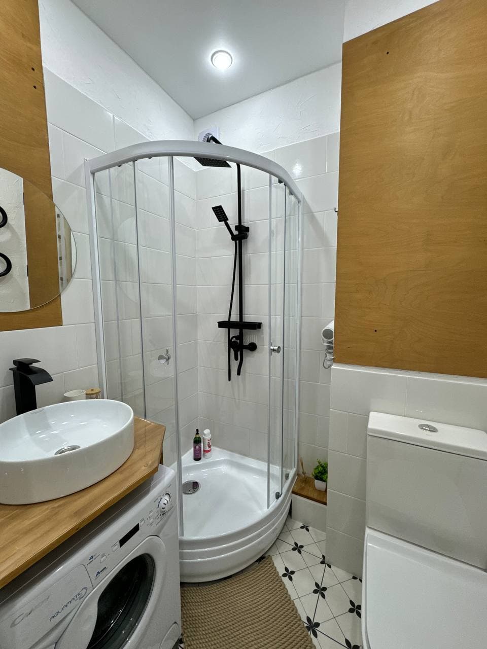 Ванная комната с душевой кабиной, раковиной и стиральной машиной