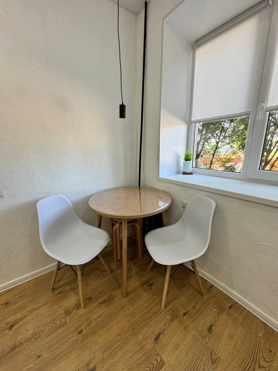 Обеденный стол у окна с двумя стульями и видом на улицу